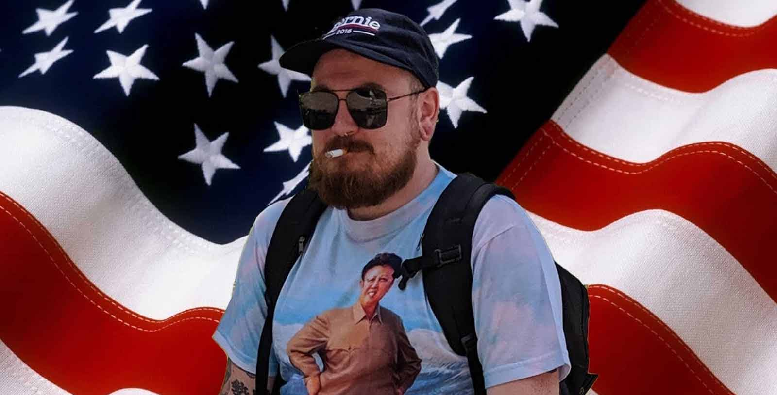 Man wearing sunglasses and a cap with an American flag in the background