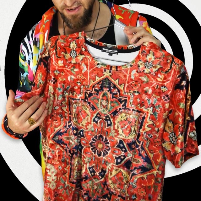 Person holding a red patterned shirt with a colorful sleeve