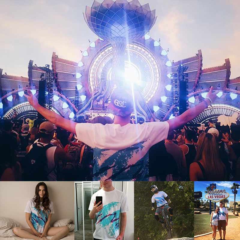 Person with arms outstretched at a concert with a large stage and audience.