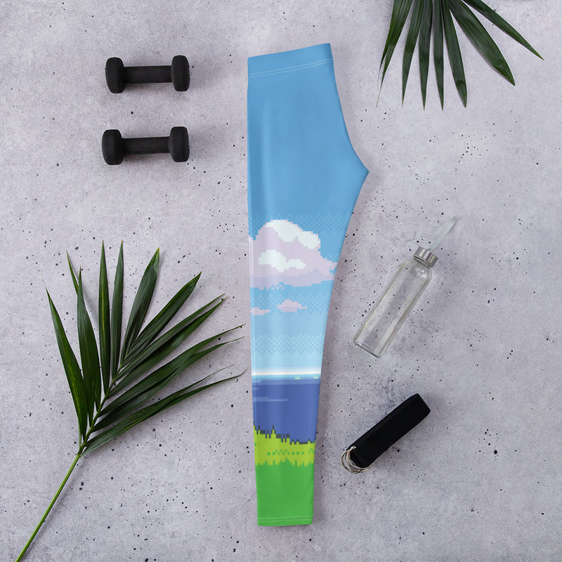 Woman wearing blue pixel art landscape print tights with clouds, sea, and grass design
