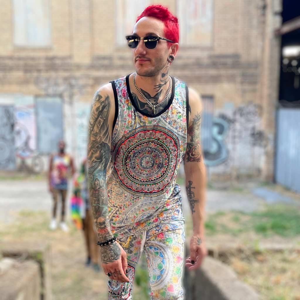 A massive radial mandala dominates the chest—concentric rings of geometric filigree, dots, and petal structures in rusty brick red and oxidized teal against parchment. Contact us with accessibility feedback, we'd love to help!